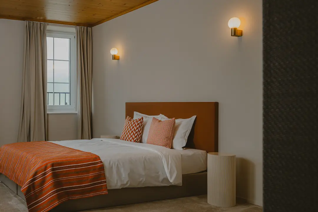 Chambre Deluxe vue Montagne : le lit, la fenêtre et le plafond en bois