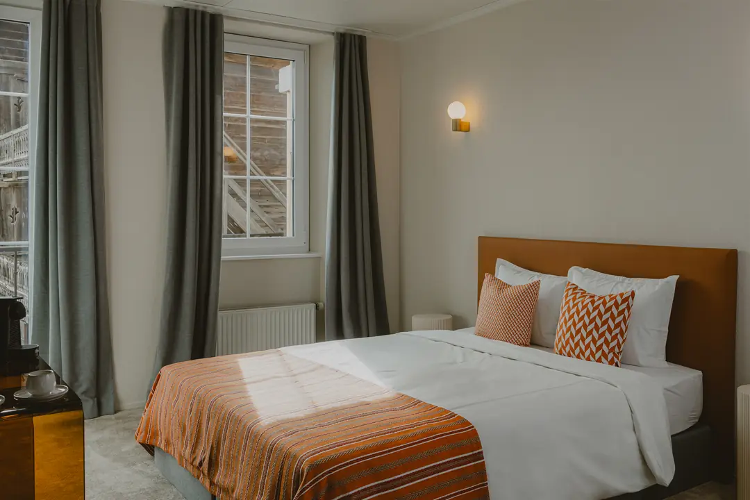 Chambre Deluxe vue Montagne : le soleil sur le lit, rideaux ouverts